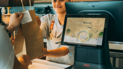 Customer receiving a takeout order at a restaurant counter while checking if restaurants accept EBT as a payment option
