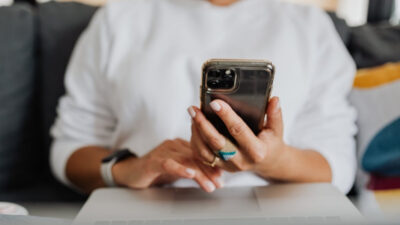 Woman checking eligibility details for a free iPhone 11 Pro Max on her smartphone in 2026
