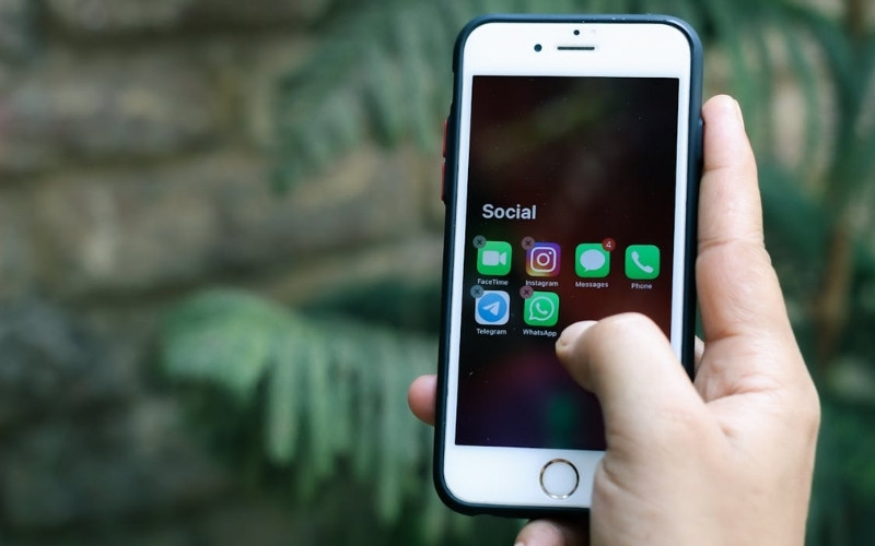 Hand using smartphone apps while researching how to get a free iphone through government assistance programs