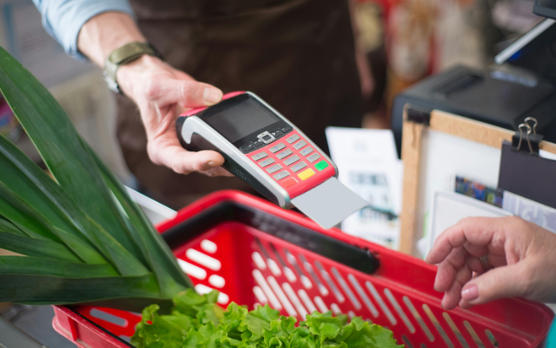 A customer uses a payment terminal to pay for groceries with SNAP benefits in Texas while making healthier choices.