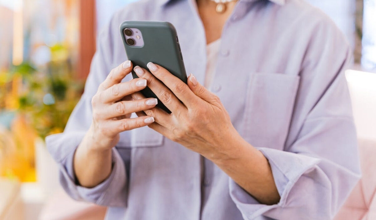 Woman checking details about iphone 11 free offer and eligibility steps on her smartphone