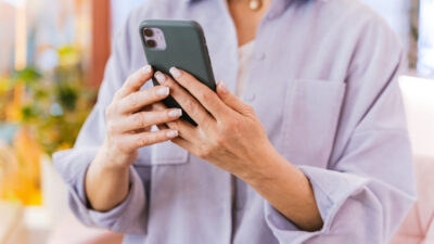 Woman checking details about iphone 11 free offer and eligibility steps on her smartphone