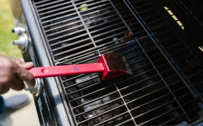 How to clean grill grates using a grill brush to remove grease and burnt residue